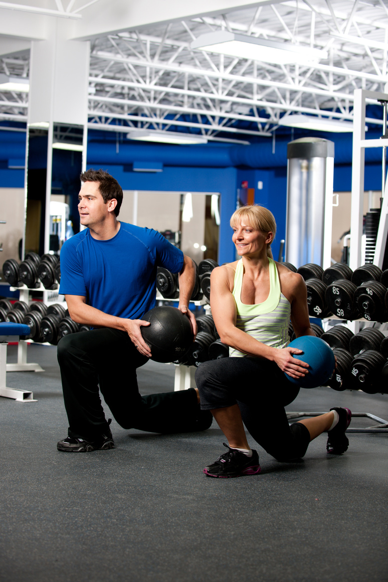 Trainer coaching a medicine ball exercise