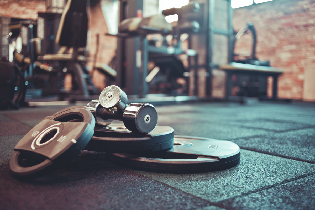 Weight plates and a dumbbell on rubber gym flooring